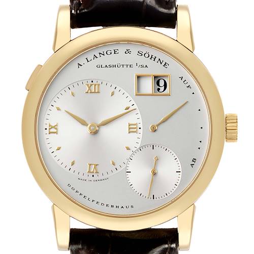 The A. Lange & Sohne Lange 1 101.021 Men's Yellow Gold Silver Dial watch is shown from a front angle, highlighting the dial, hands, date, and power reserve indicators.