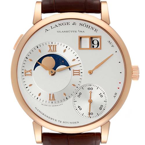 The image shows a close-up view of the Lange 1 watch by A. Lange & Söhne, displaying the dial, moon phase, date window, and power reserve indicator.